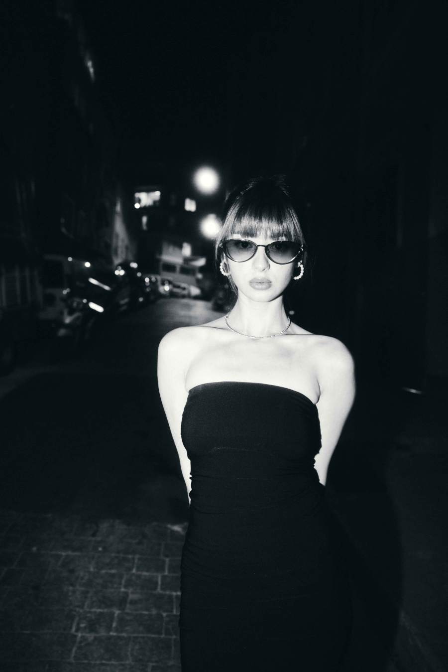 Gece sokağında siyah elbiseyle siyah-beyaz kare